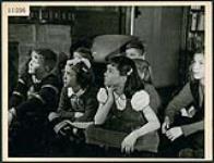 Seven children gather for Saturday morning story time at the London Ontario public library March 1945