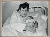 Close-up portrait of a mother holding her newborn infant in the maternity ward of the Ottawa Civic Hospital March 1945