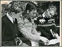 Muriel Brazer, Louis B. de Passille et Gunnild Moller déterminent leurs parcours de la journée sur une carte de la région à l'auberge Ste-Adèle March 1945
