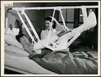 Private M. Robinson in Christie St. Hospital, Toronto, undergoing a stomach-hand-leg skin graft with Nursing Sister Sadler April 1945