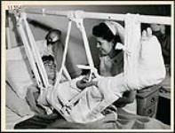 Private M. Robinson in Christie St. Hospital, Toronto, undergoing a stomach-hand-leg skin graft with Nursing Sister Sadler April 1945
