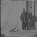 Ann MacDonald avec un pigeon devant un édifice [1944]
