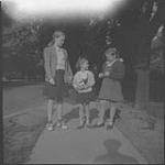 Ann MacDonald and two girls on a sidewalk [1950]