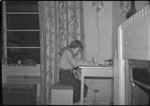 Ann MacDonald writing at a desk [1950]