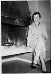 Dorothy Ann MacDonald assise près d'un foyer 1955