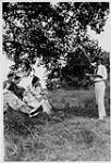 Wilson P. MacDonald faisant la lecture à un groupe de gens sous un arbre [1926]