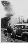 Wilson P. MacDonald and Dorothy Ann MacDonald standing in front of a car [1938]