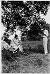 Wilson P. MacDonald faisant la lecture à un groupe de gens sous un arbre [1925]