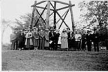 Wilson P. MacDonald, Dorothy Ann MacDonald et un groupe de gens devant une tour en bois [1935]