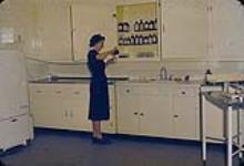 Nurse pouring liquid into a bottle in doctor's office n.d.
