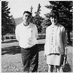 Man and woman standing in a park [ca. 1970]
