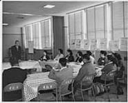 Groupe d'hommes et de femmes autochtones assis autour de tables, Programme de formation des agents de santé communautaire, Calgary [between 1960 and 1970]