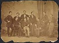 Groupe d'hommes prenant la pose dans un studio de photographie [ca 1875-1910]