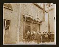Group of men and women standing outside the Dusault & Proulx publishing house during the winter [ca. 1875-1910]