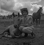 Jeannie pets her buckskin foal, Trail Riders, Williams Lake, British Columbia [ca1954-1963]