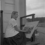 L'artiste Jane Lanier en train de peindre, Kitimat, Colombie-Britannique 13 juin 1956.