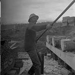 Homme construisant un pont en bois de cèdre, Kitimat, Colombie-Britannique 15 juin 1956.