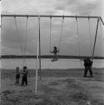 Enfants jouant sur des balançoires, Swan River, Manitoba 23 juin 1956.
