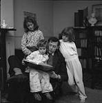 Homme faisant la lecture à des enfants, famille Piper [ca.1954-1963]