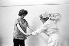 Infirmière et femme se tenant la main [ca1954-1963]