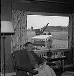 Gordon Hollingsworth en train de lire, baie Frobisher, T.N.-O., [Iqaluit (anciennement baie Frobisher), Nunavut] [between June 17-August 24, 1960].