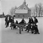 Group of Metis Children on a seesaw in Île-à-la-Crosse, Saskatchewan [ca. 1954-1963].