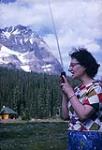 Alice holding a walkie-talkie and "calling Mount D'Orsay" to make contact with the climbers 1954