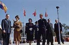 Princess Elizabeth standing on stage with Prince Philip, three men and two women, Ontario. [Between October 8th and November 10th 1951].