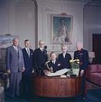 Prince Philip signs the membership book of the Royal Society of Canada, prior to receiving a diploma designating him an Honorary Fellow at Government House, Ottawa, Oct. 14, 1957. The honor was bestowed in recognition of his encouragement of the humanities and sciences. Standing from left to right are officers of the society: Dr. Charles Camsell, Dr. L.S. Russell, Dr. T.W.N. Cameron, president Le October 14, 1957.