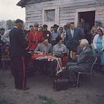Governor General Vanier paying treaty money to the Indians at Cold Lake. It is believed that this was the first time that a Governor General of Canada actually presented the treaty money. Cold Lake, Alberta.  [Le gouverneur général Vanier assis avec des amérindiens payant l'argent de traité à Cold Lake, Alberta.] juin 1961