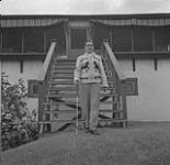 Man standing in front of a chalet at Camp Fortune n.d.