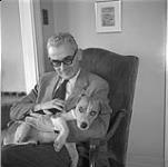 Jean-Paul Lemieux tenant son chien Bruno [entre 1955-1963].