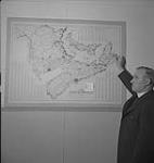 Les Highland Games, Antigonish, 1940, homme à côté d'une carte des provinces maritimes 1940