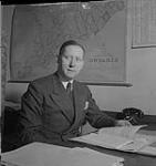 Toronto, homme non identifié assis à un bureau devant une carte de l'Ontario [between 1939-1951].