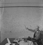 Saskatoon & Wheat, unidentified man pointing to a map of the province of Saskatchewan [between 1939-1951].
