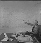 Saskatoon et blé, homme non identifié pointant la province de la Saskatchewan sur une carte [between 1939-1951].