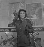 Hôpital Women's College. Une femme non identifiée en uniforme devant les nouvelles affiches de l'armée du Canada [entre 1939-1951]