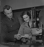 Woman's College Hospital.  Unidentified Man in Uniform Helping Unidentified Woman in Uniform With Machinery [entre 1939-1951]