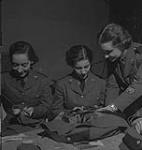 Service féminin de la Force aérienne, années 1940. Trois femmes non identifiées en uniforme font de la couture [between 1940-1949]