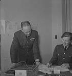 Service féminin de la Force aérienne, années 1940. Des hommes non identifiés en uniforme examinent des documents [entre 1940-1949]