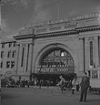 Winnipeg, années 1940. Un homme non identifié marche devant la station Union des Chemins de fer nationaux du Canada [between 1940-1949]