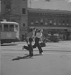 Winnipeg, années 1940. Une femme non identifiée court avec une valise [between 1940-1949]