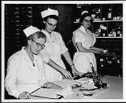 Three nurses in the chart room at St. Joseph's Hospital, Victoria. Nurses and Nursing. Department of Citizenship and Immigration, Information Division [entre 1930-1960]
