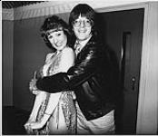 Jim Waters, Assistant Program Director of CHUM-AM radio, grabs an armful of Solid Gold Girl as he accepts delivery of Toronto's first single, Even The Score. Toronto [between 1980-1990]