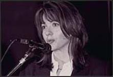 Snap-shot of an unidentified woman speaking / singing into a microphone [entre 1990-2000]