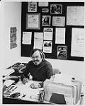 Richard Flohil assis à un bureau. Toronto octobre 1977