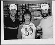 À Lloydminster, Alberta, Brian Good (à gauche) et Bruce Good (à droite) du groupe The Good Brothers de Solid Gold Records, participent à une entrevue en direct avec l'animateur de l'émission du retour à la maison de CKSA 1080, Brian Kilbank (au centre) [between 1980-1983].