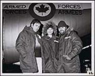 Le duo Gary and Dave en compagnie d'une femme non identifiée, devant un aéronef des Forces armées canadiennes [entre 1973-1976].