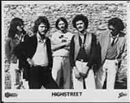 Press portrait of Highstreet standing against a stone wall [entre 1979-1981].