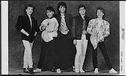 Members of Haywire standing in front of a fabric backdrop [entre 1982-1993].